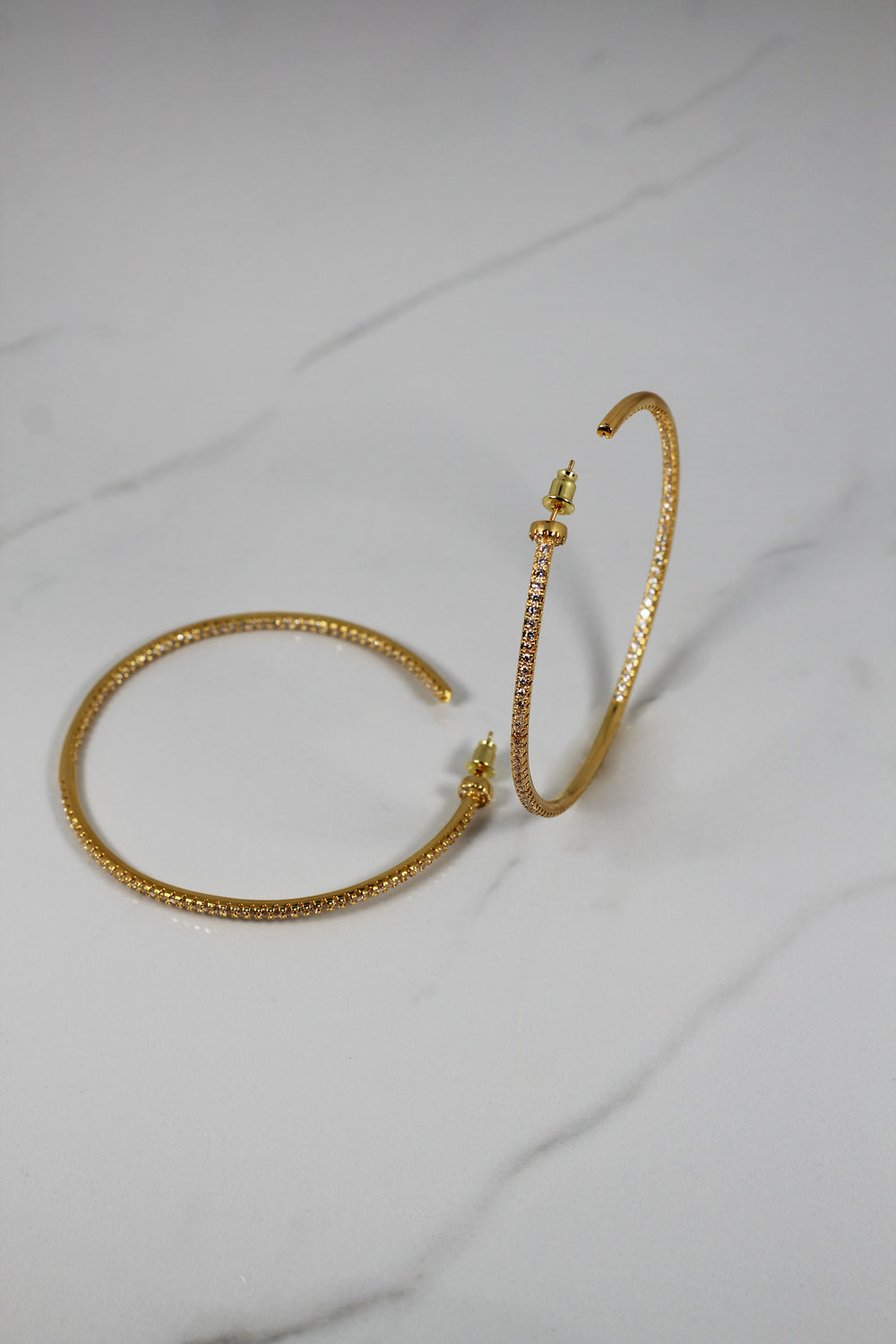 Gold plated hoop earrings with CZ stones, sparkling and lightweight fashion jewelry for women, perfect for adding a flirty touch to everyday or night-out looks.