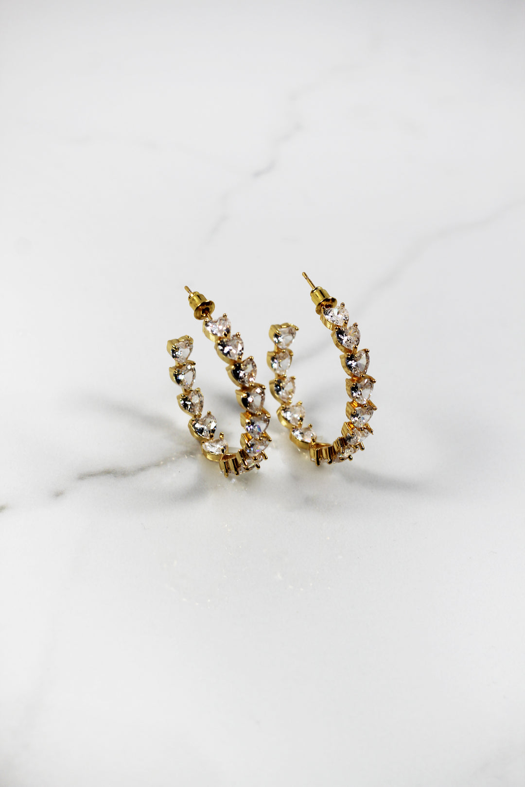 Gold plated heart hoop earrings with CZ stones, sparkling and lightweight fashion jewelry for women, perfect for adding a flirty touch to everyday or night-out looks.