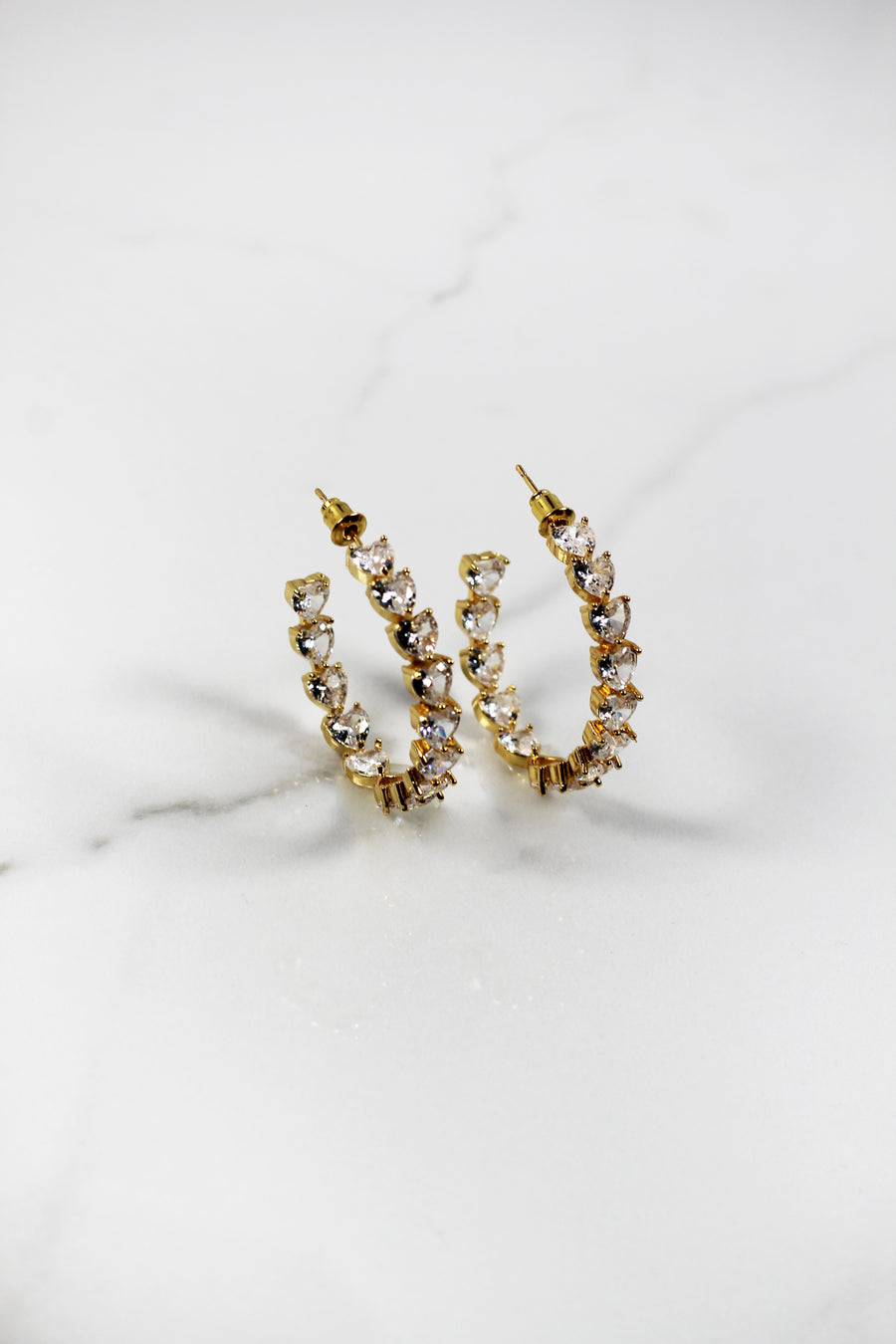 Gold plated heart hoop earrings with CZ stones, sparkling and lightweight fashion jewelry for women, perfect for adding a flirty touch to everyday or night-out looks.