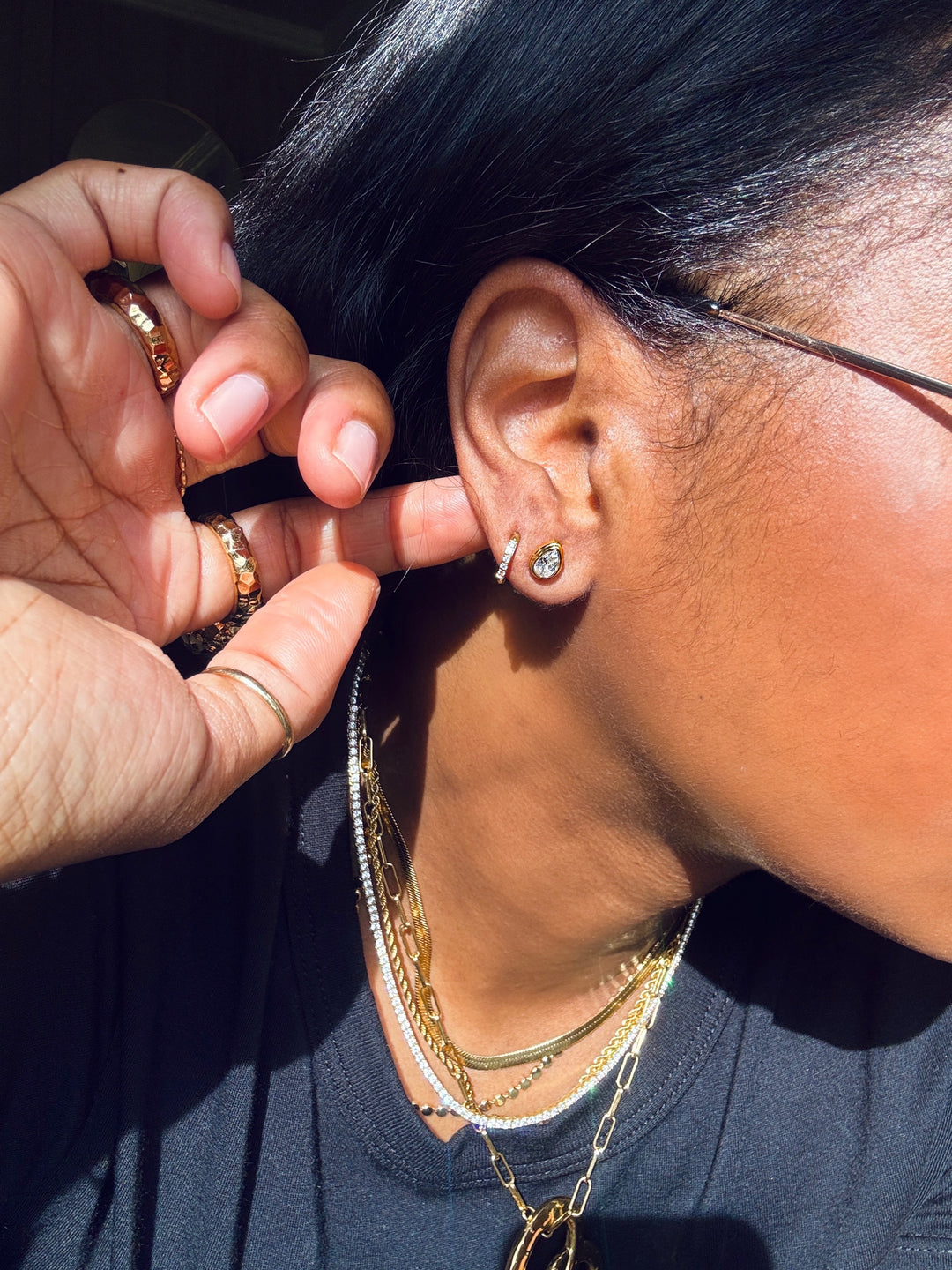 Pic of gold studs and huggies earrings on a model
