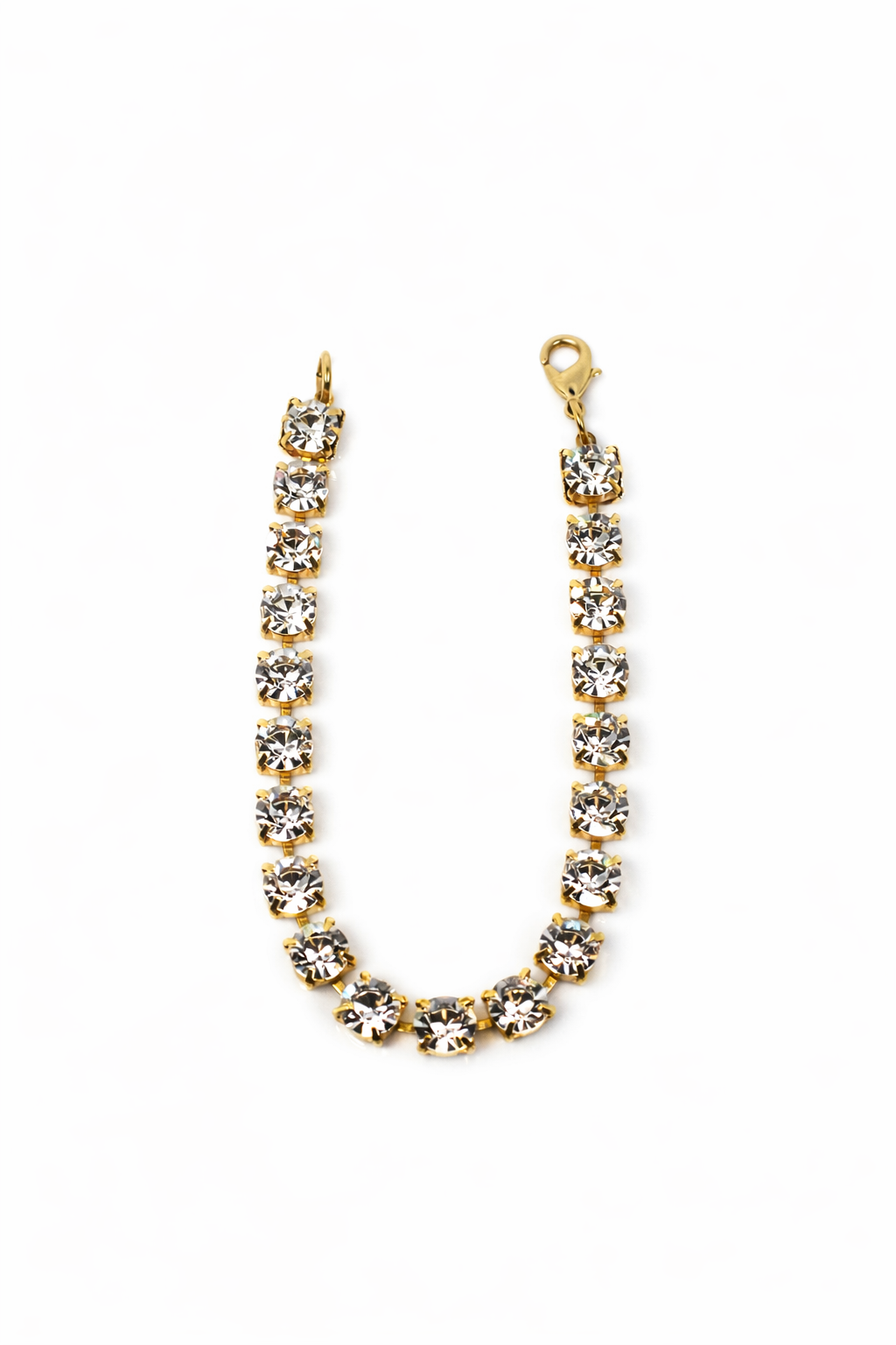 Gold bracelet with clear stones on a white background