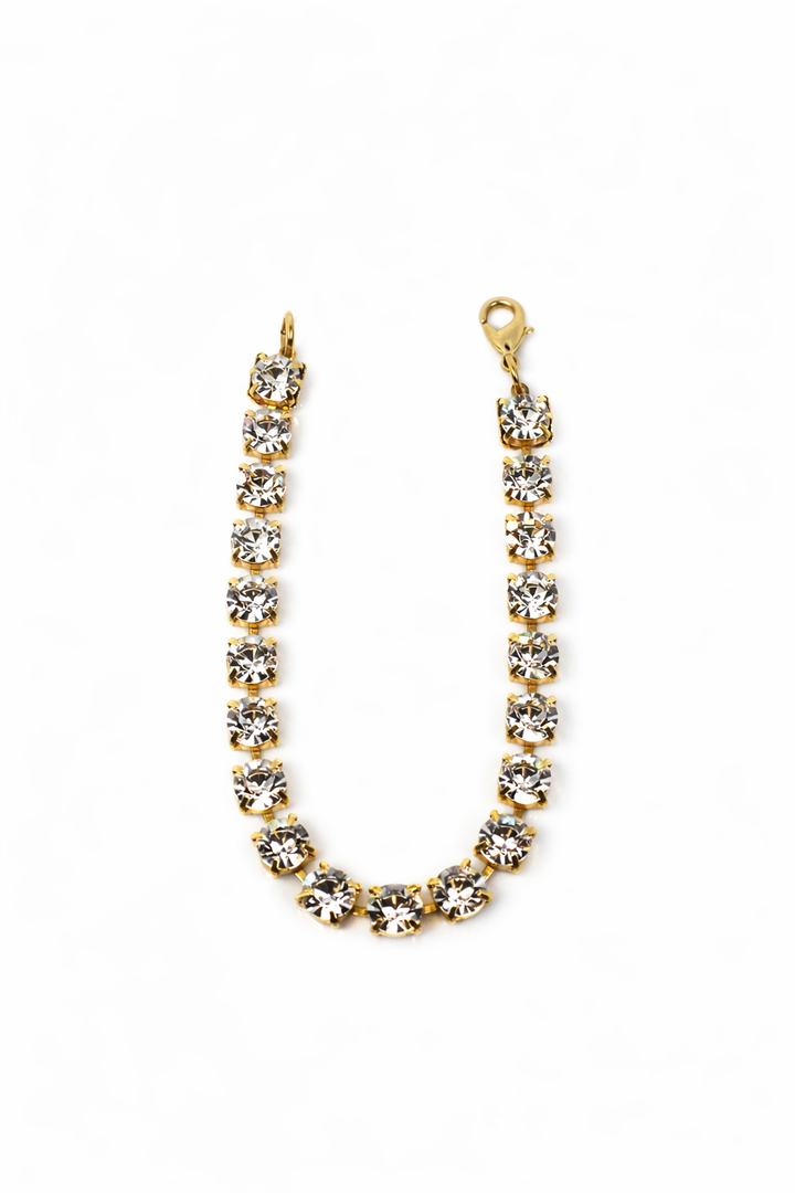 Gold bracelet with clear stones on a white background