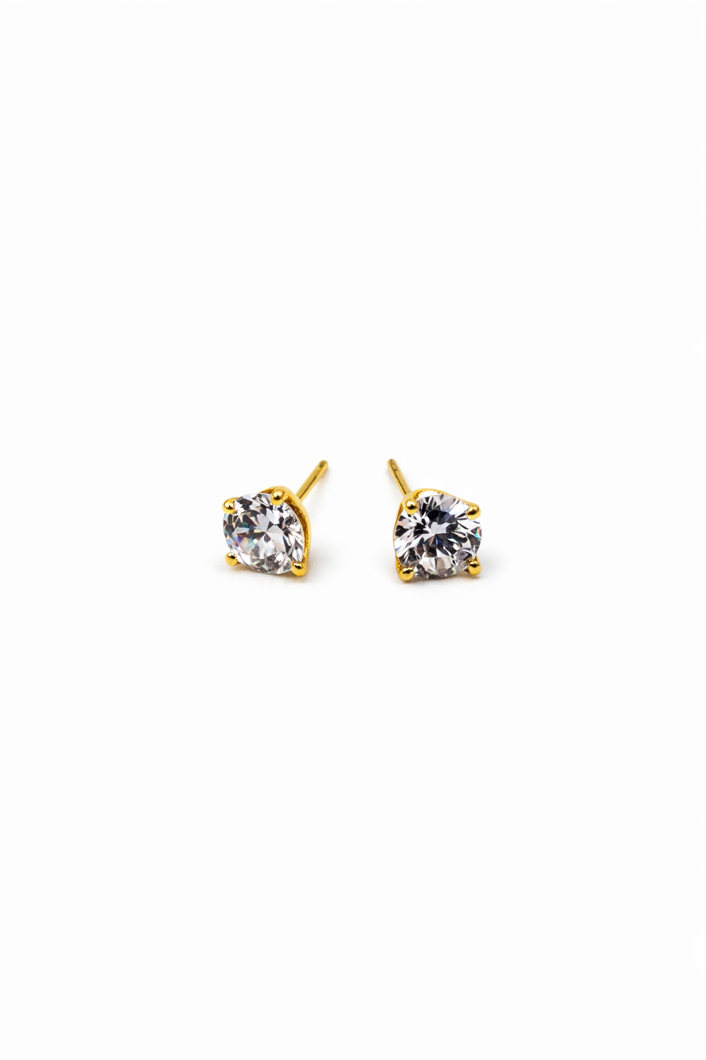 Pair of gold stud earrings with clear gemstones on a white background