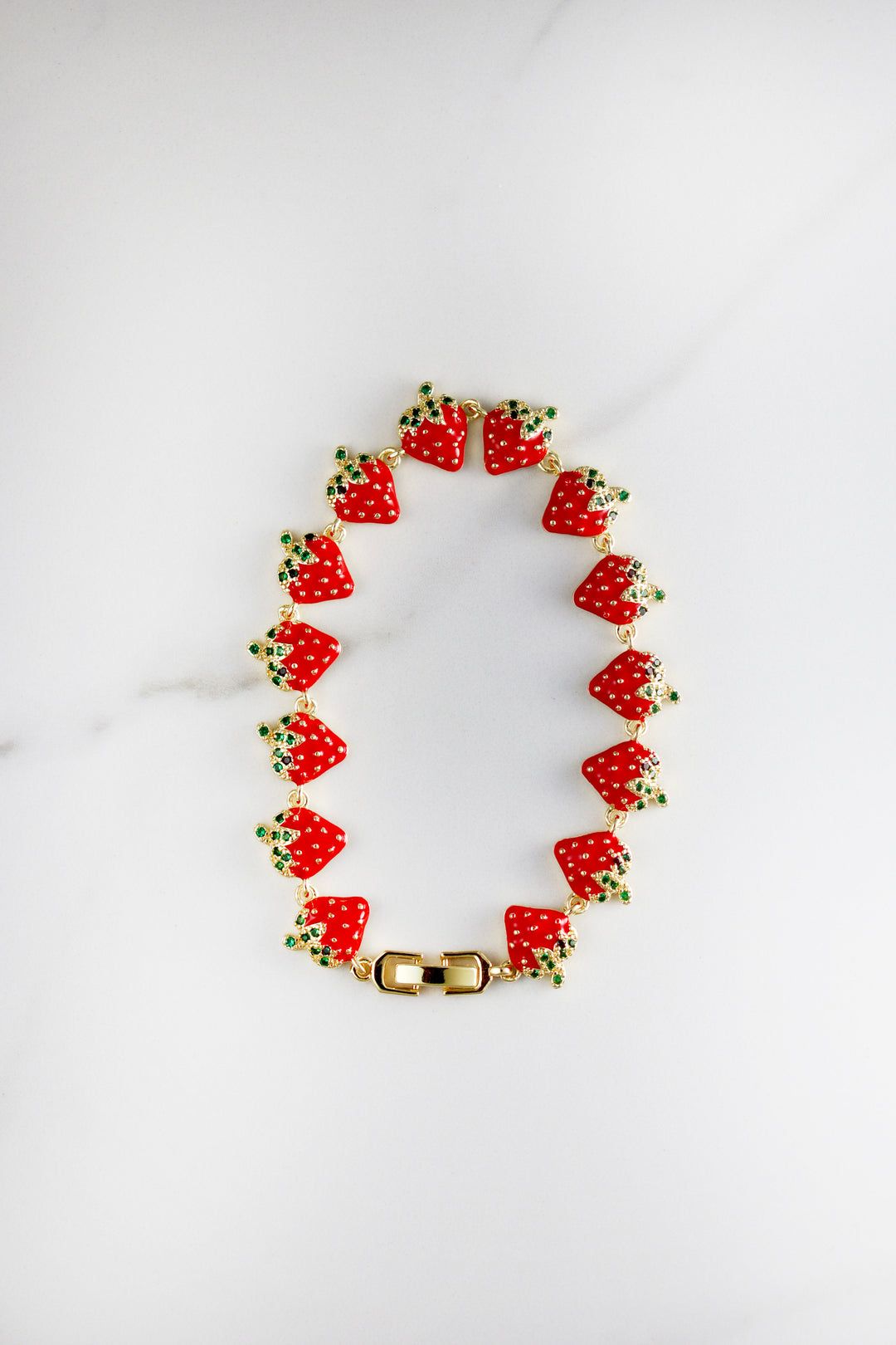 Gold plated strawberry charm bracelet with CZ stones, affordable and playful costume jewelry for women, perfect for summer stacking or gifting.

