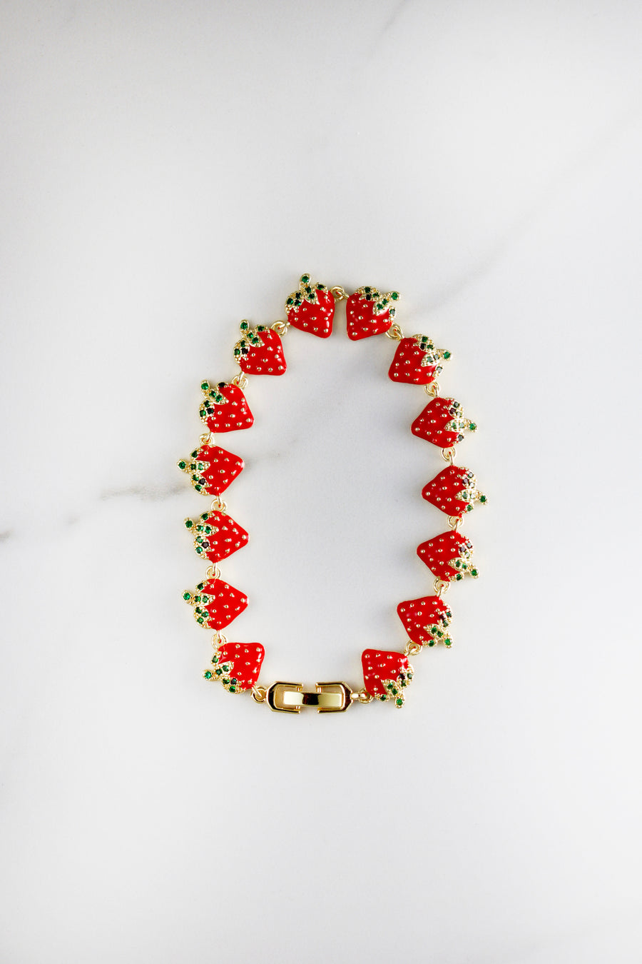 Gold plated strawberry charm bracelet with CZ stones, affordable and playful costume jewelry for women, perfect for summer stacking or gifting.


